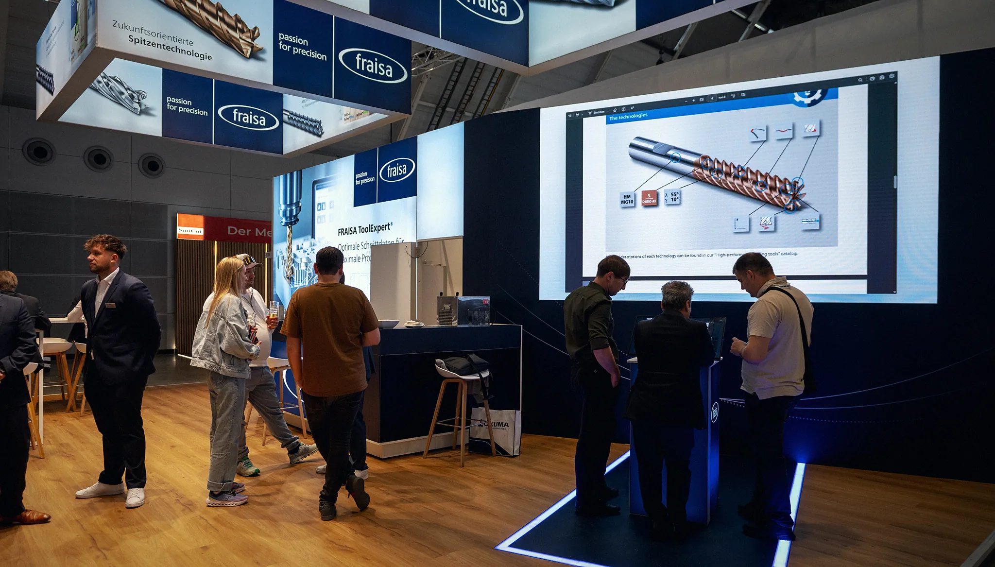 Fraisa-Messestand auf der AMB 2026: Besucher am Touch-Terminal vor der LED-Wand mit dem Digital PitchDeck